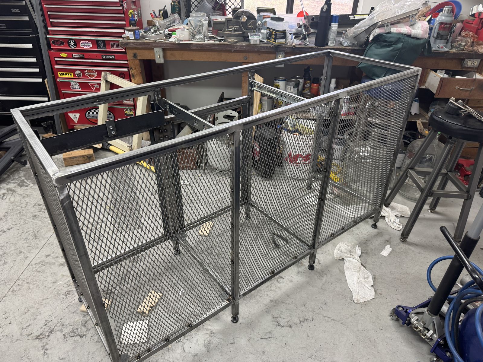 Upper cabinet frame with expanded-metal mesh panels.